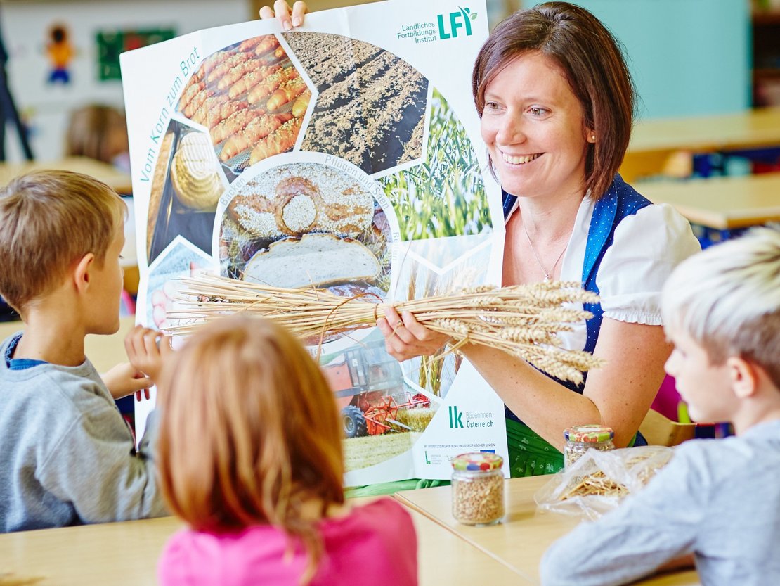 Bäuerin erklärt Kindern anhand eines Plakates