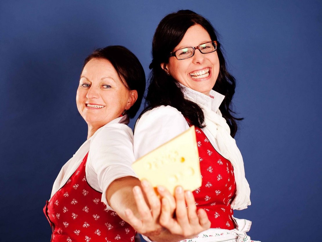 Zwei Seminarbäuerinnen präsentieren ein Stück Käse